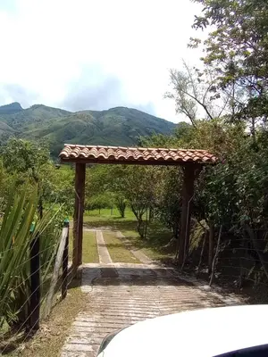a wooden archway on a road with mountains in the background at Don tranquilo in Concepción