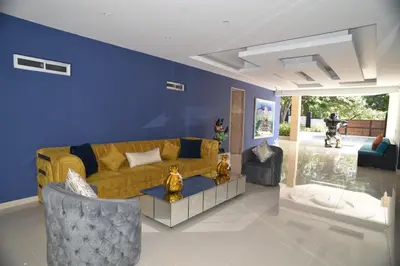 a living room with a yellow couch and two chairs at Finca Dubai in San Jerónimo