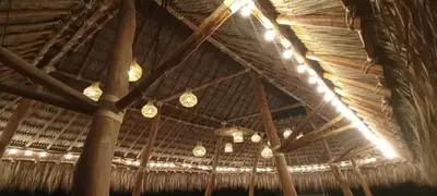 a group of lights hanging from a straw roof at Finca Dubai in San Jerónimo
