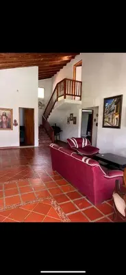 a living room with a couch and a staircase at FINCA LA MIEL en Barbosa Antioquia in Barbosa