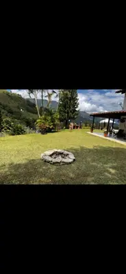 a dog laying on the grass in a field at FINCA LA MIEL en Barbosa Antioquia in Barbosa