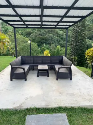 a patio with a couch and two tables under a pergola at FINCA LA MIEL en Barbosa Antioquia in Barbosa