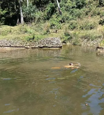 a person swimming in a body of water at HOSTAL - COLIVING - Cerca MetroCable ARVI in Guarne