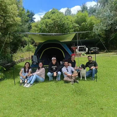 a group of people sitting in front of a tent at HOSTAL - COLIVING - Cerca MetroCable ARVI in Guarne