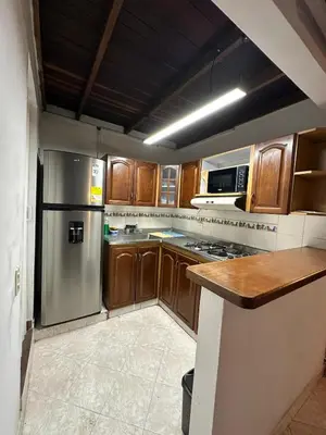 a kitchen with wooden cabinets and a stainless steel refrigerator at Apto con vista en distrito cultural de Medellín in Medellín