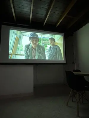 a projection screen with two men on it in a room at Apto con vista en distrito cultural de Medellín in Medellín