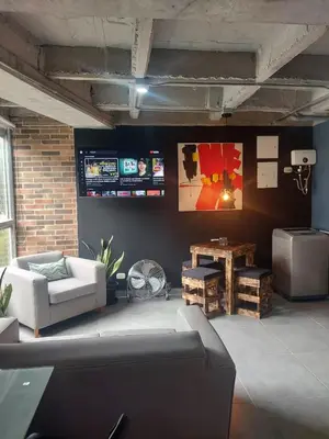a living room with a couch and a tv at Stylish Laureles Loft in Medellin in Medellín