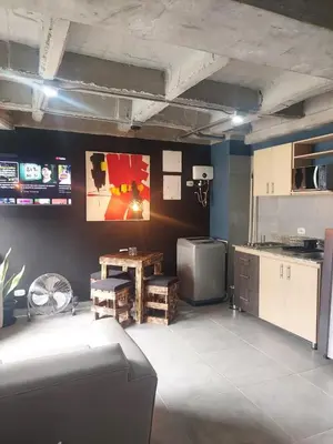 a kitchen with a table and a tv in a room at Stylish Laureles Loft in Medellin in Medellín