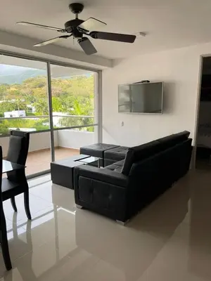 a living room with a black couch and a tv at Encantador alojamiento en San Jerónimo in San Jerónimo