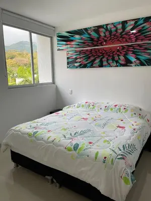 a bedroom with a bed with a painting on the wall at Encantador alojamiento en San Jerónimo in San Jerónimo
