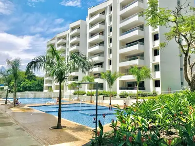 an apartment building with a swimming pool and palm trees at Encantador alojamiento en San Jerónimo in San Jerónimo