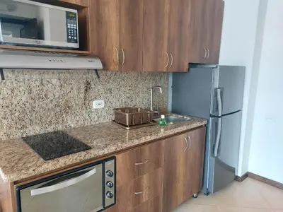 a kitchen with a sink and a microwave at Laureles penthouse, jacuzzi-rooftop fun in the sun in Medellín
