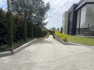 a brick walkway next to a building with trees at Casa en Rionegro, a pocos minutos del aeropuerto in Rionegro