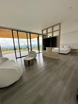 a living room with a television and white furniture at Casa en Rionegro, a pocos minutos del aeropuerto in Rionegro