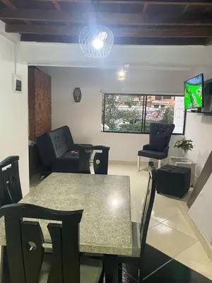 a living room with a table and a couch at Apartamento Medellin Cordova in Medellín