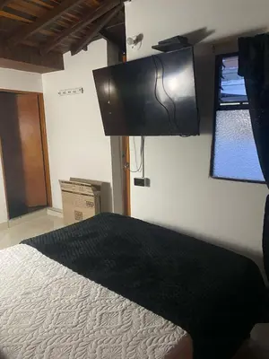 a bedroom with a bed and a television on the wall at Apartamento Medellin Cordova in Medellín