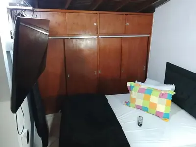 a small bedroom with a bed with a wooden cabinet at Apartamento Medellin Cordova in Medellín