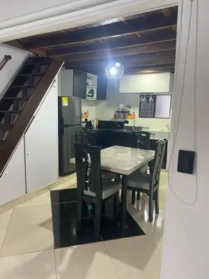 a kitchen with a table and chairs in a room at Apartamento Medellin Cordova in Medellín