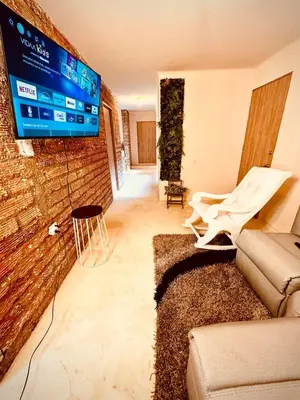 a living room with a couch and a tv on a brick wall at The best of Envigado, close to everything in Envigado