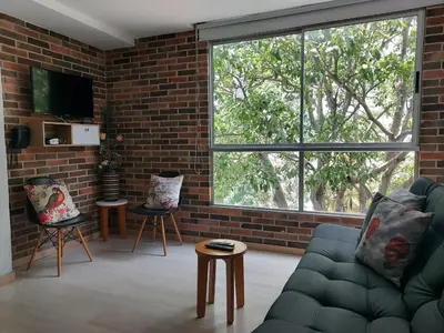 a living room with a couch and a brick wall at Medellin, Bring your toothbrush, in Laureles in Medellín