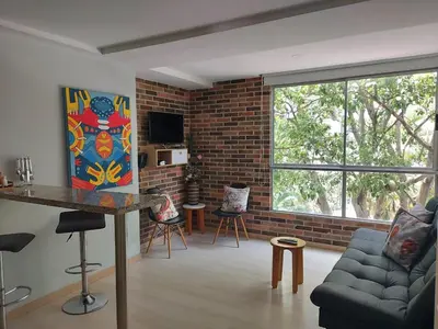 a living room with a couch and a brick wall at Medellin, Bring your toothbrush, in Laureles in Medellín