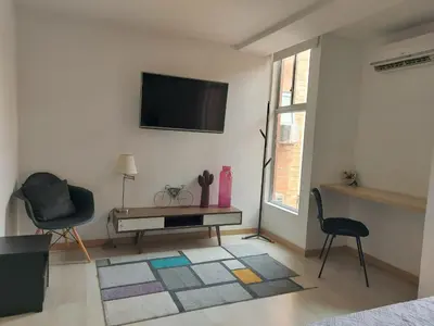 a living room with a television and a table and chairs at Medellin, Bring your toothbrush, in Laureles in Medellín