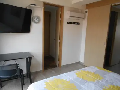 a bedroom with a bed and a desk and a television at Best apartment, best location, Laureles Paradise in Medellín