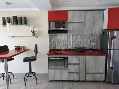 a kitchen with red cabinets and a red counter top at Best apartment, best location, Laureles Paradise in Medellín