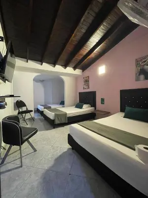 a hotel room with two beds and a chair at Hotel boutique san pablo H5 in Medellín