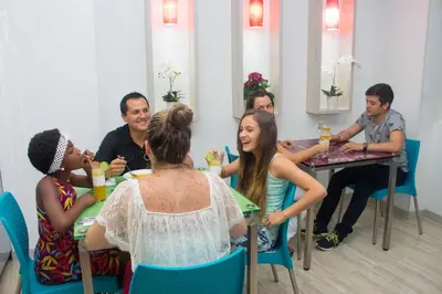 a group of people sitting at a table with drinks at Hotel Sixtina Plaza Medellin in Medellín