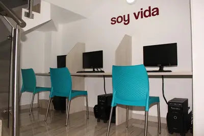 a table with four chairs and two computer monitors at Hotel Sixtina Plaza Medellin in Medellín