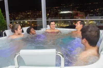 a group of people in a hot tub at night at Hotel Sixtina Plaza Medellin in Medellín