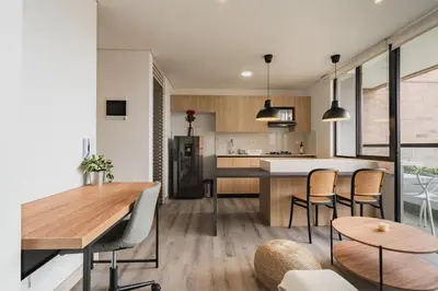 a kitchen and living room with a table and chairs at Grand By Jalo in Medellín