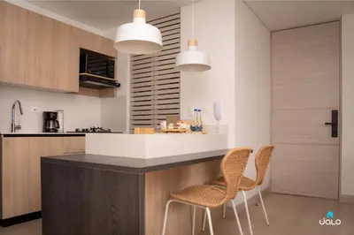 a kitchen with two chairs and a counter with two lights at Grand By Jalo in Medellín