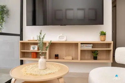 a living room with a table and a tv at Grand By Jalo in Medellín