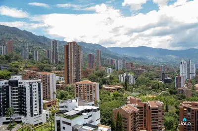 a city with tall buildings and mountains in the background at Grand By Jalo in Medellín