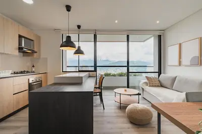 a kitchen and living room with a couch and a table at Grand By Jalo in Medellín