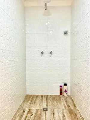 a bathroom with a shower with white walls and wooden floors at Digital nomads, everything close Ac Wi-fi fast in Medellín