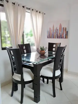 a black dining room table and chairs with a glass table at Apartamento renovado parque La Floresta, reserva minimo de 21 dias in Medellín
