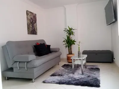 a living room with a couch and a table at Apartamento renovado parque La Floresta, reserva minimo de 21 dias in Medellín