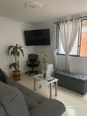 a living room with a couch and a table at Apartamento renovado parque La Floresta, reserva minimo de 21 dias in Medellín