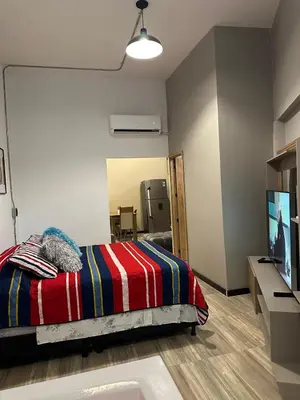 a bedroom with a bed and a television and a sink at Apartamento parque poblado lleras jacuzzi aire provenza in Medellín