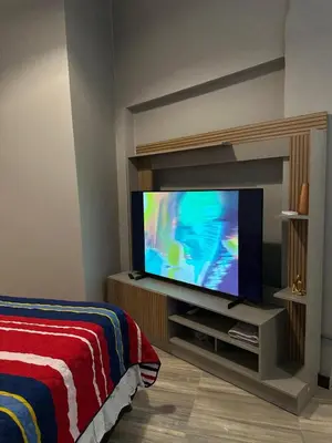 a bedroom with a flat screen tv on a entertainment center at Apartamento parque poblado lleras jacuzzi aire provenza in Medellín