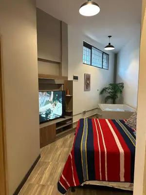 a living room with a tv and a bed in a room at Apartamento parque poblado lleras jacuzzi aire provenza in Medellín