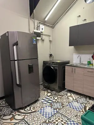 a kitchen with a refrigerator and a washing machine at Apartamento parque poblado lleras jacuzzi aire provenza in Medellín