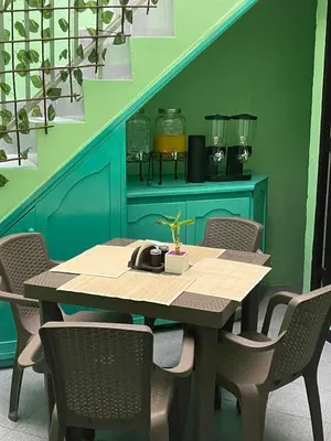 a dining room table with chairs and a green wall at Hotel boutique san pablo H4 in Medellín