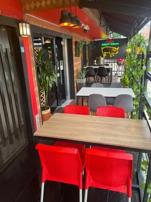 a table and red chairs in front of a restaurant at Hotel boutique san pablo H4 in Medellín