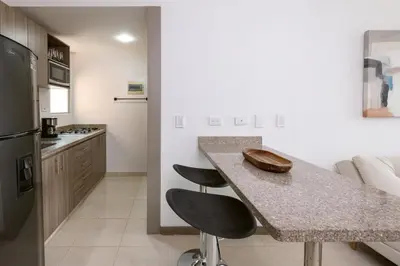 a kitchen with a counter and two stools at a kitchen island at Mirador Verde by MOME in Medellín