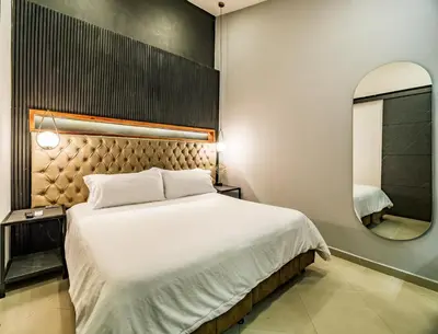 a bedroom with a large bed and a mirror at One Apartments Lleras in Medellín