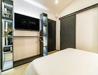 a bedroom with a bed and a closet at One Apartments Lleras in Medellín